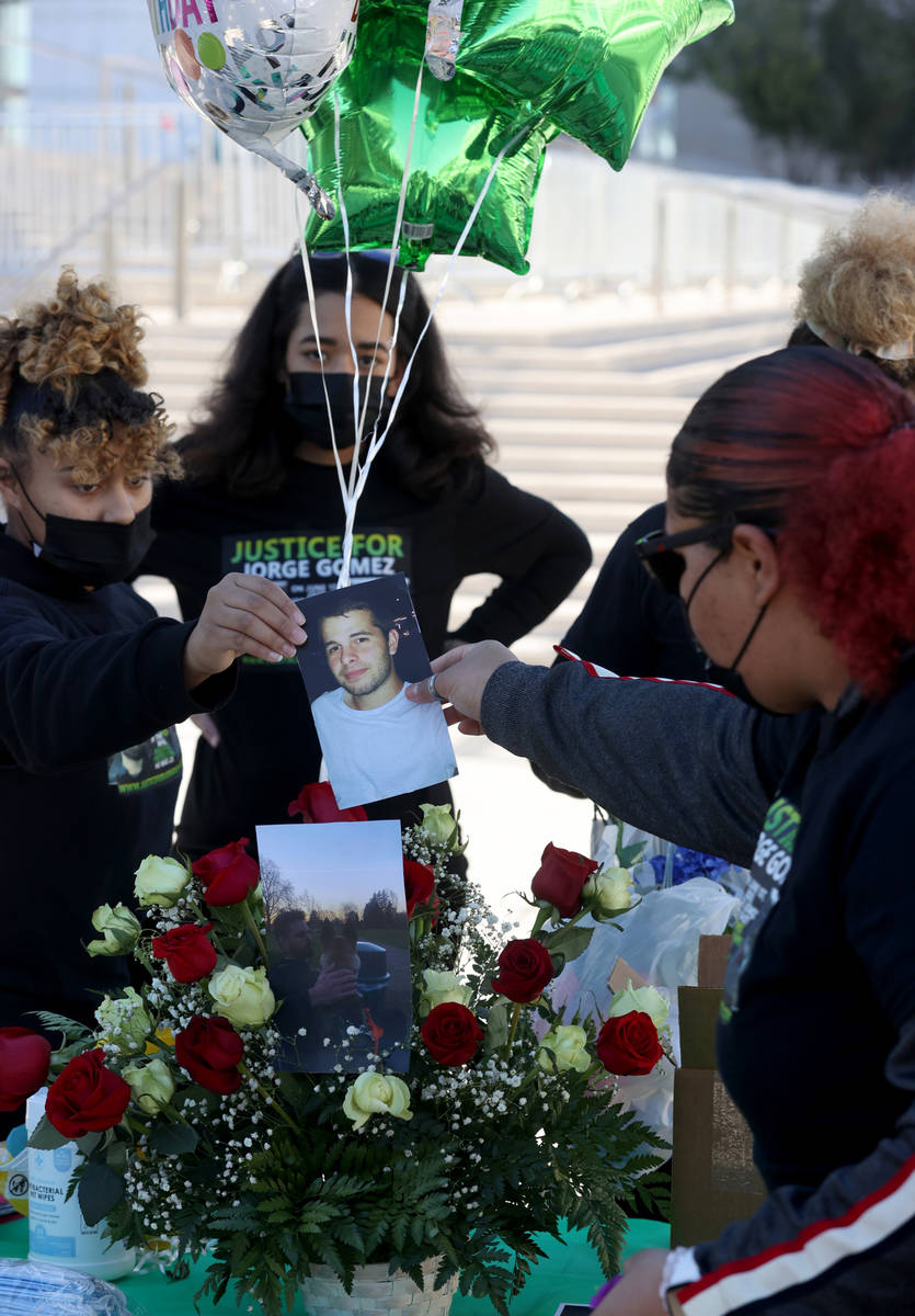 Desiree Smith of "More Than A Hashtag" hands a photo of Jorge Gomez, a Black Lives Matter prote ...