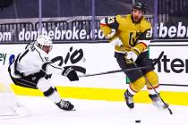 Golden Knights defenseman Alec Martinez (23) skates with the puck under pressure from Los Angel ...