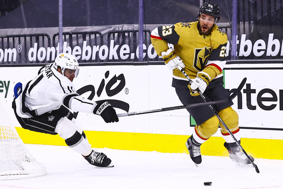 Golden Knights defenseman Alec Martinez (23) skates with the puck under pressure from Los Angel ...