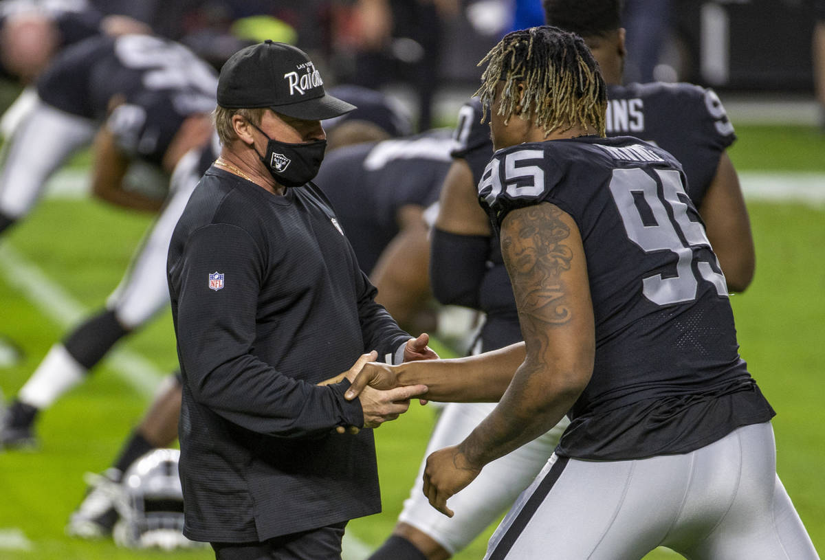 Las Vegas Raiders head coach Jon Gruden greets defender David Irving (95) before the start of t ...