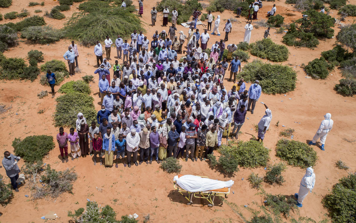 FILE - In this April 30, 2020, file photo, mourners gather to bury an elderly man believed to h ...