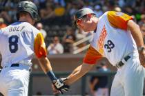 Base runner Skye Bolt (8) is congratulated on a score by Aviators manager Fran Riordan (39) as ...