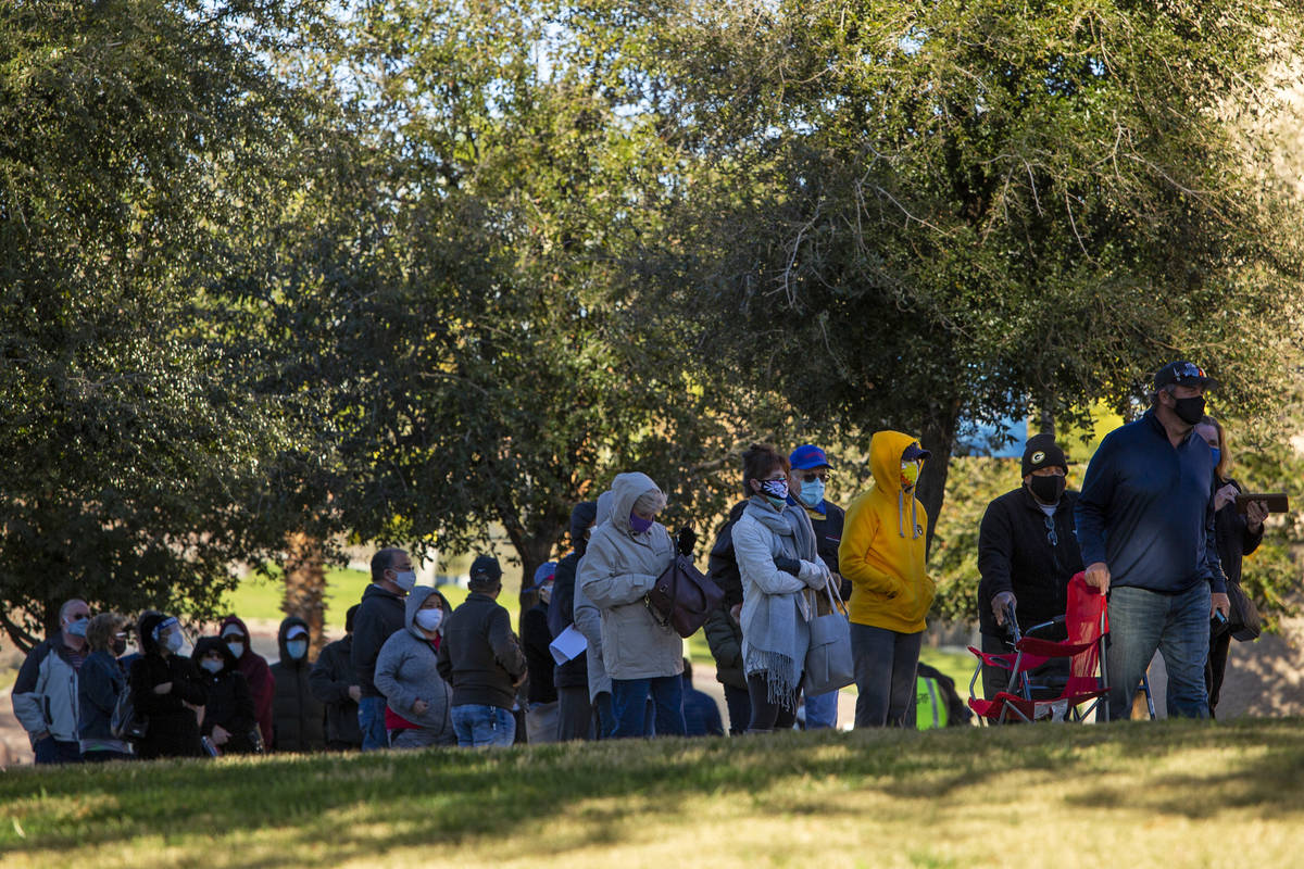 People wait in line for their COVID-19 vaccine at Cashman Field on Saturday, Feb. 20, 2021, in ...