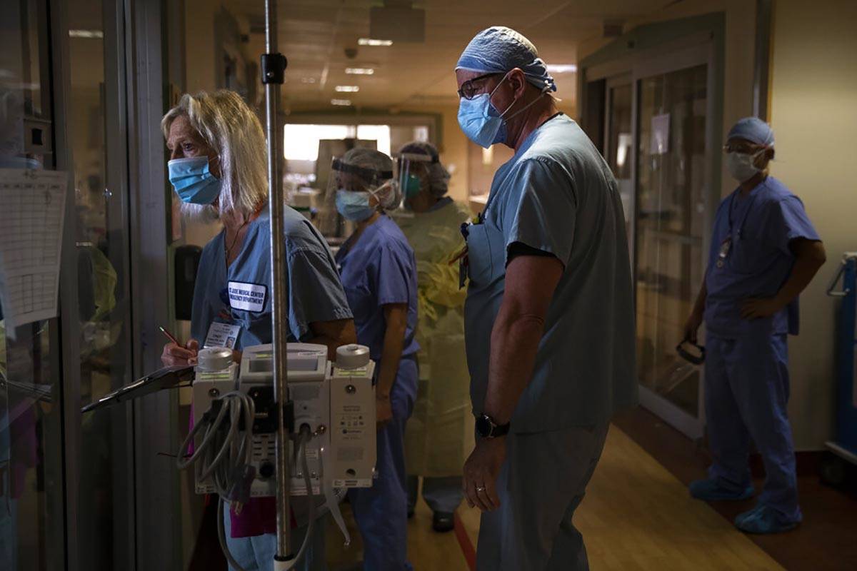 In this July 7, 2020, file photo, Nurse Cindy Kelbert, left, checks on a critically ill COVID-1 ...