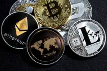 A close up of ethereum ripple litecoin bitcoin dash coins shot in metallic black background in ...