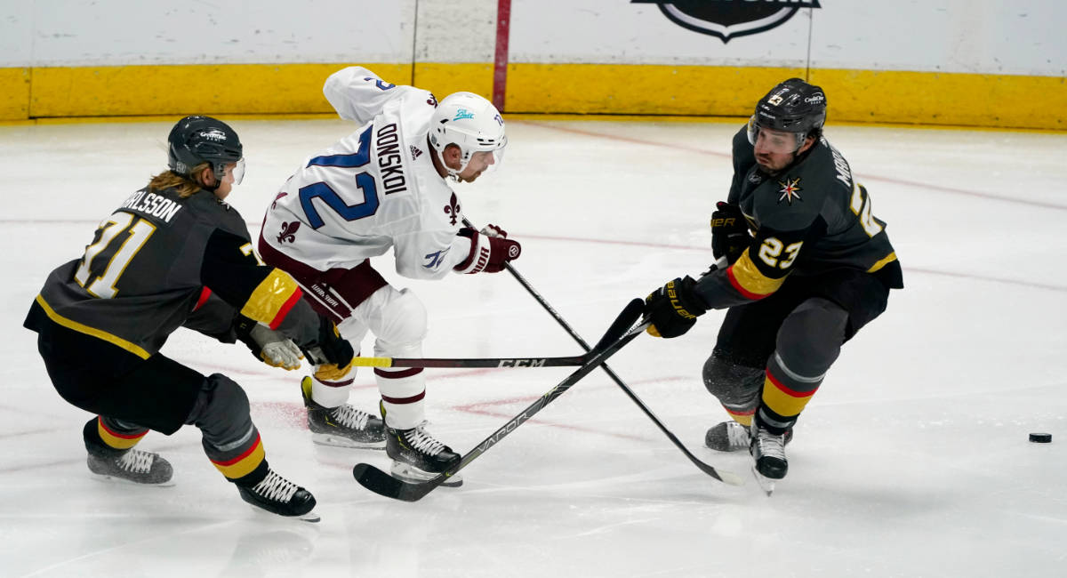 Colorado Avalanche right wing Joonas Donskoi, center, drives between Vegas Golden Knights cente ...