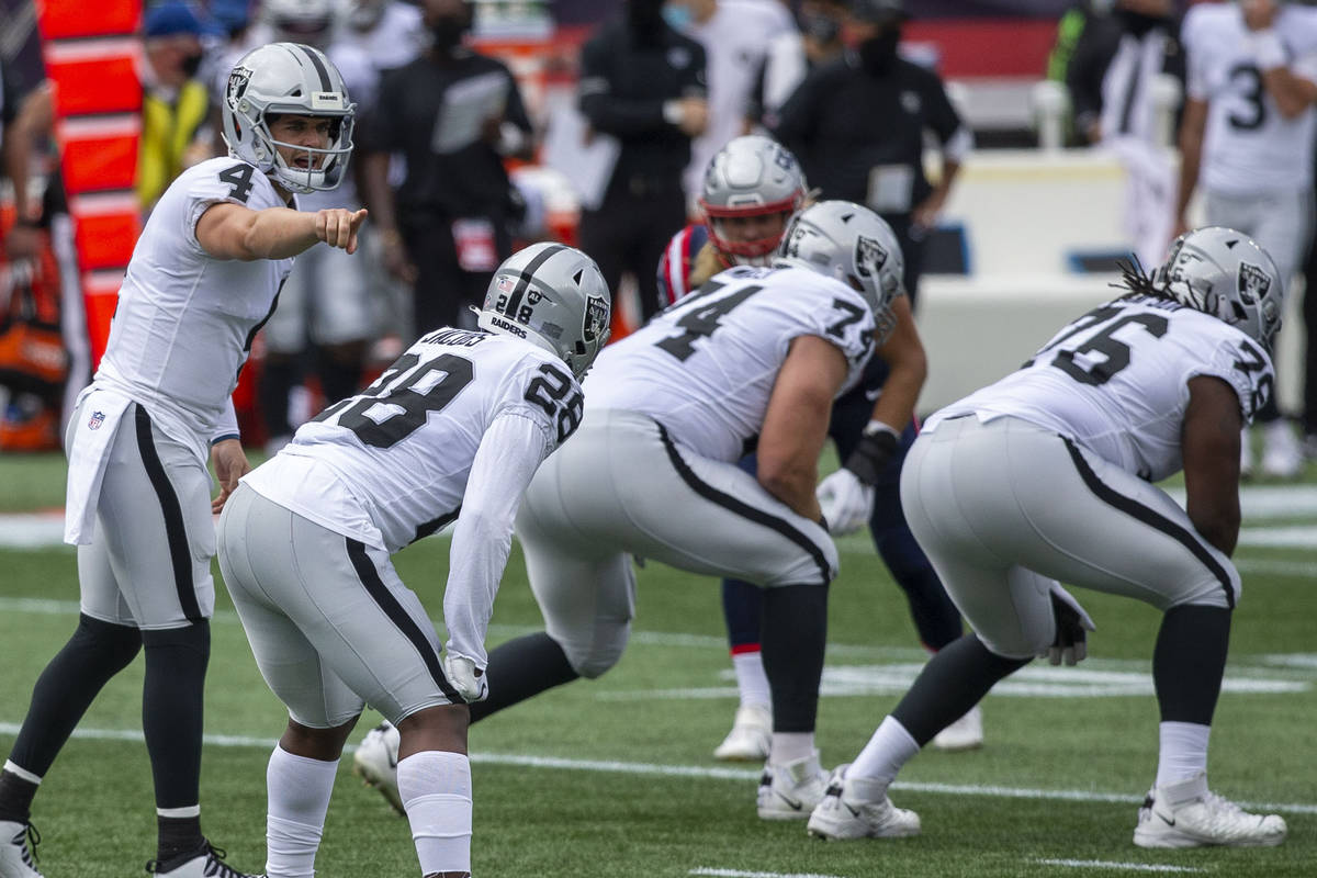 Las Vegas Raiders quarterback Derek Carr (4) calls a play at the line of scrimmage with running ...