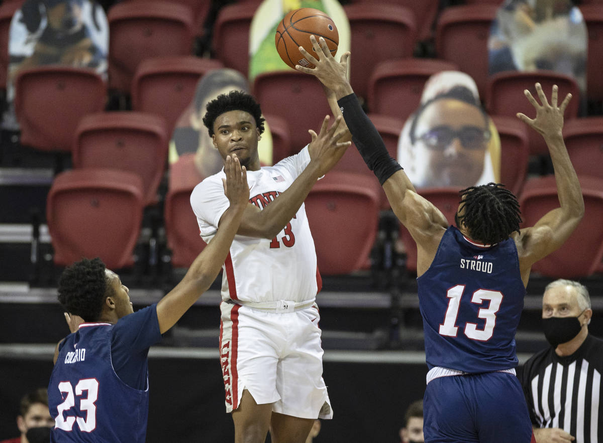 UNLV Rebels guard Bryce Hamilton (13) passes the ball over Fresno State Bulldogs forward Leo Co ...