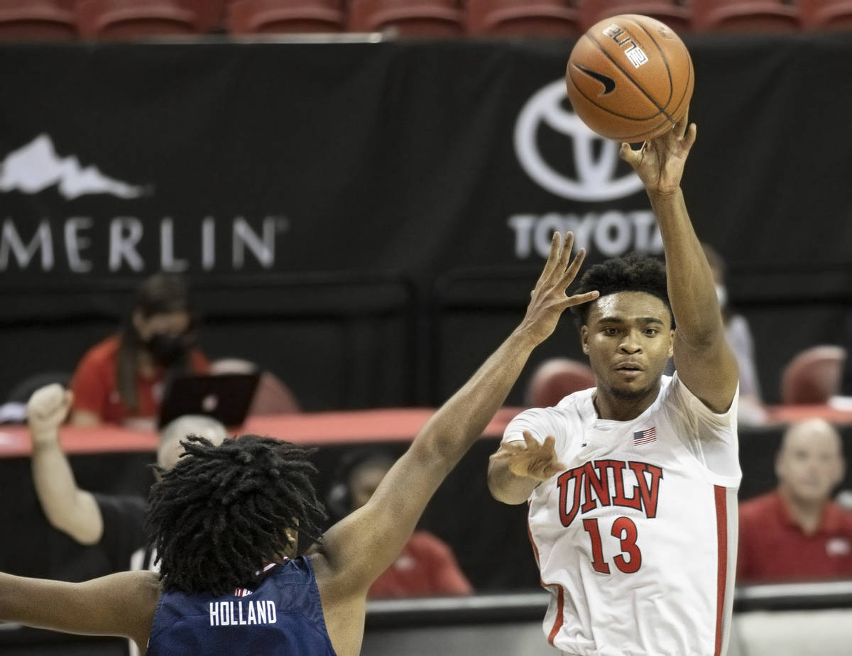 UNLV Rebels guard Bryce Hamilton (13) passes the ball over Fresno State Bulldogs guard Anthony ...