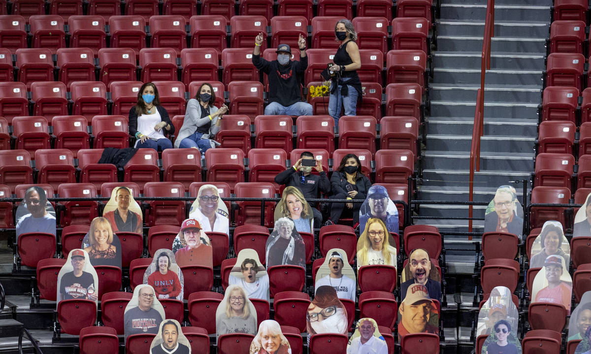 Some of the 100 fans in the stands during the first half of an NCAA menÕs basketball game ...