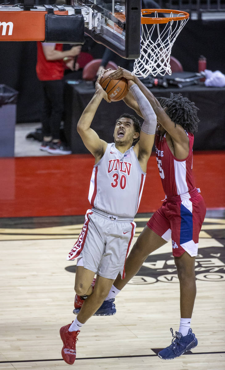 UNLV Rebels forward Devin Tillis (30) is fouled from behind by Fresno State Bulldogs guard Anth ...