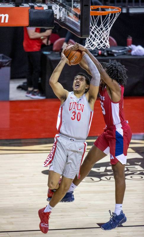 UNLV Rebels forward Devin Tillis (30) is fouled from behind by Fresno State Bulldogs guard Anth ...