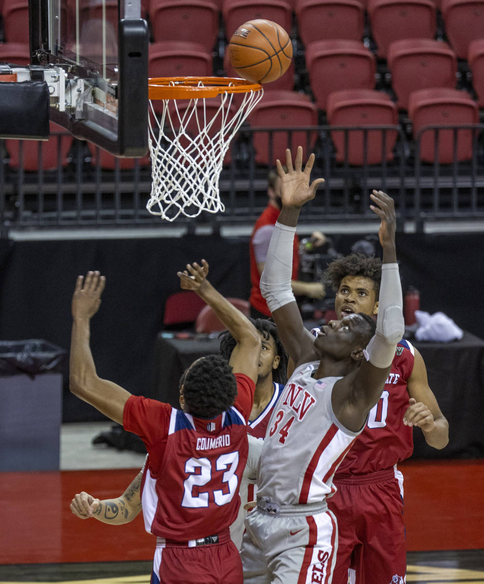 UNLV Rebels forward Cheikh Mbacke Diong (34) gets a shot off in front of Fresno State Bulldogs ...