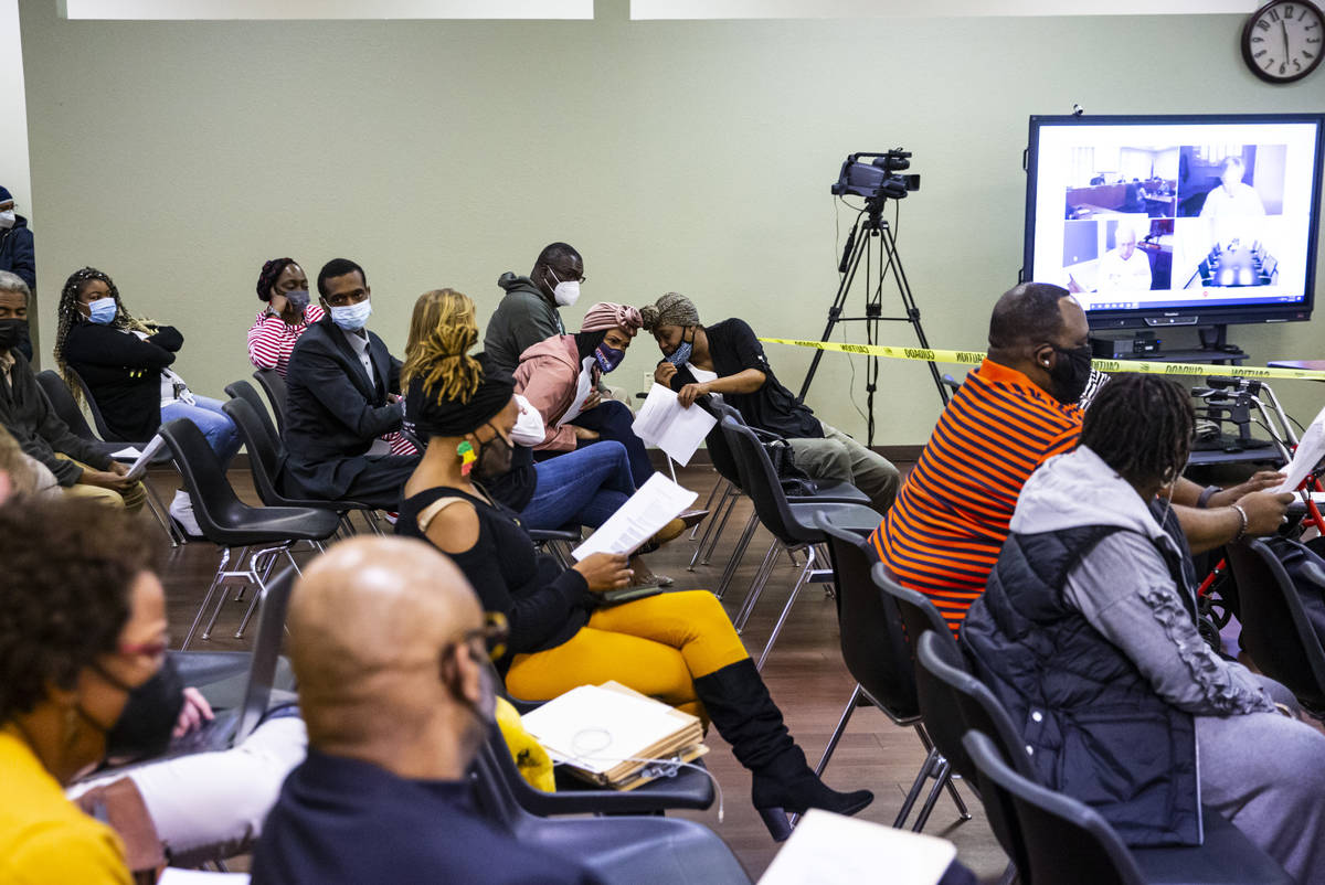 Attendees examine the agenda items at a Southern Nevada Regional Housing Authority board meetin ...