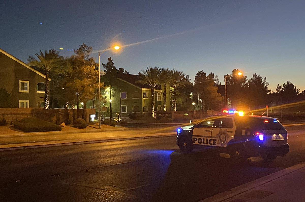 A police unit blocks a road as officers respond to a report of a woman with a hatchet in a cond ...