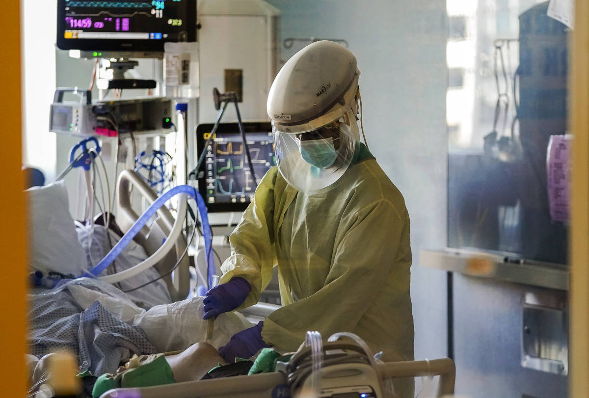 FILE - In this Wednesday, Jan. 13, 2021 file photo, a healthcare worker tends to a COVID-19 pat ...