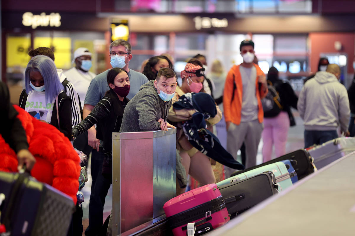 In this Jan. 22, 2021, file photo, masked travelers retrieve their luggage in baggage claim Te ...