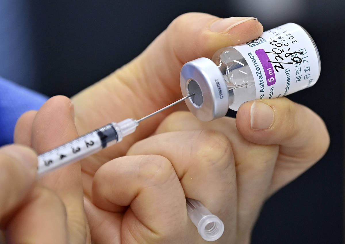 A nurse fills a syringe with the AstraZeneca COVID-19 vaccine at a health care center in Seoul ...