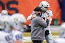 Raiders head coach Jon Gruden, left, hugs Raiders quarterback Derek Carr (4) during warm ups be ...