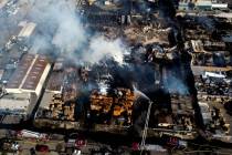 Firefighters battle a fire at a commercial yard in Compton, Calif., on Friday, Feb. 26, 2021. ...