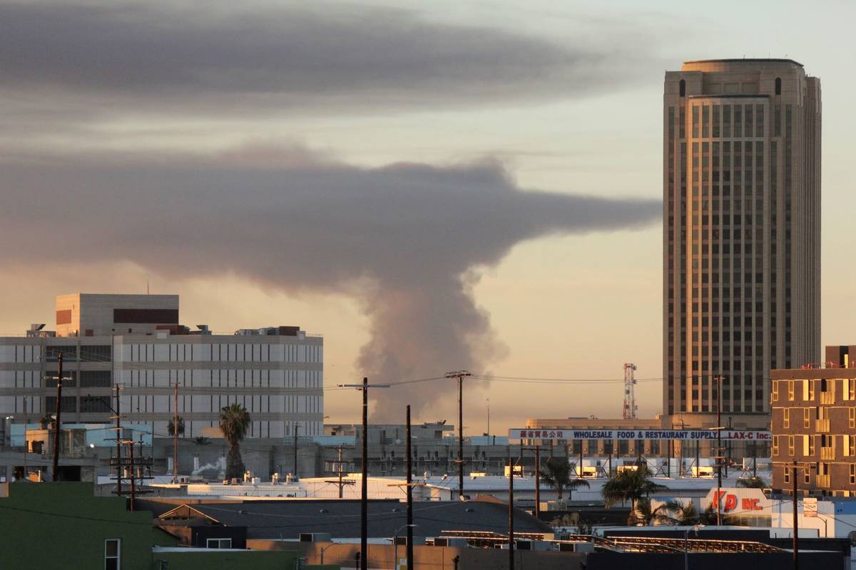 n this view from Los Angeles, smoke rises in the distance from a fire at at commercial yard in ...