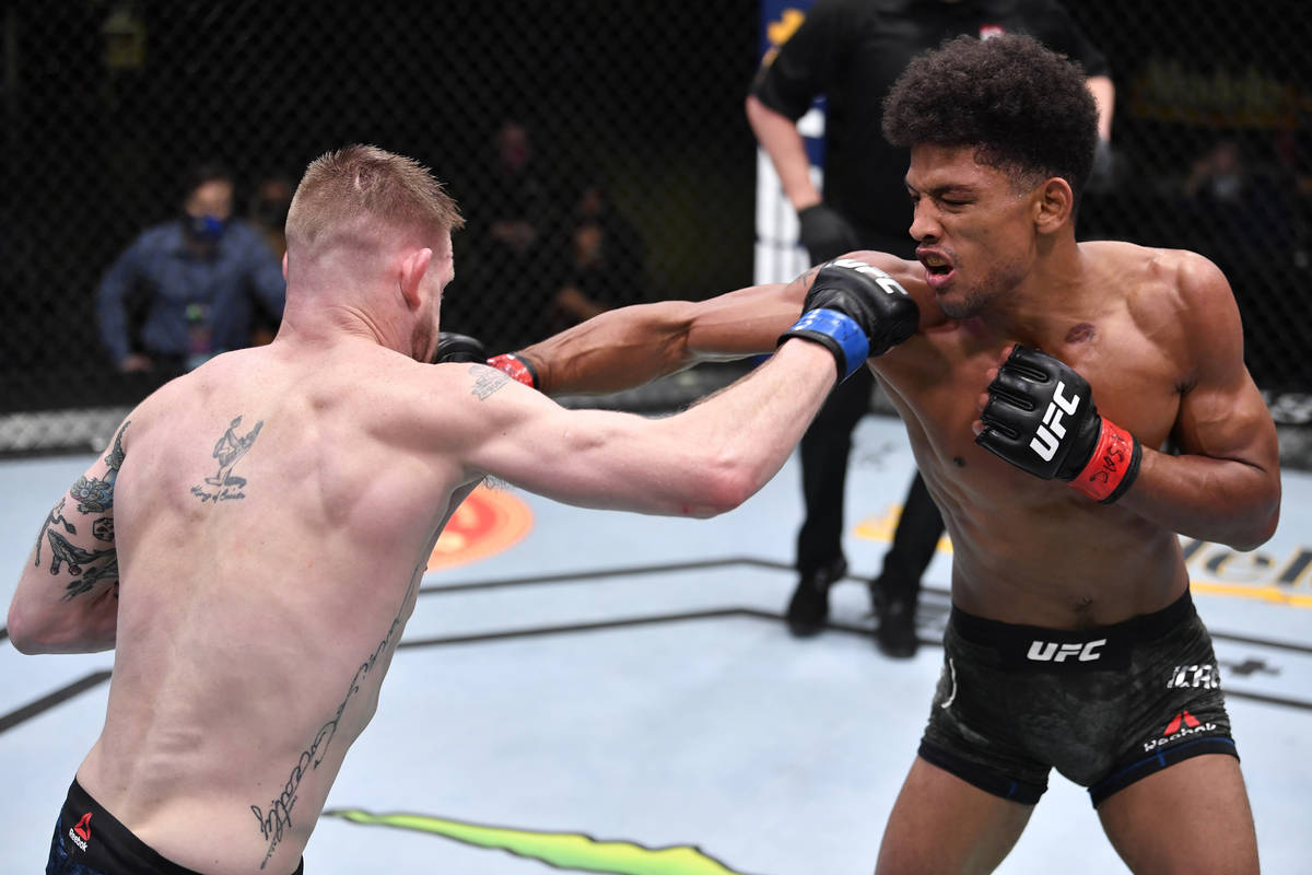 LAS VEGAS, NEVADA - FEBRUARY 27: (R-L) Alex Caceres punches Kevin Croom in a featherweight bout ...