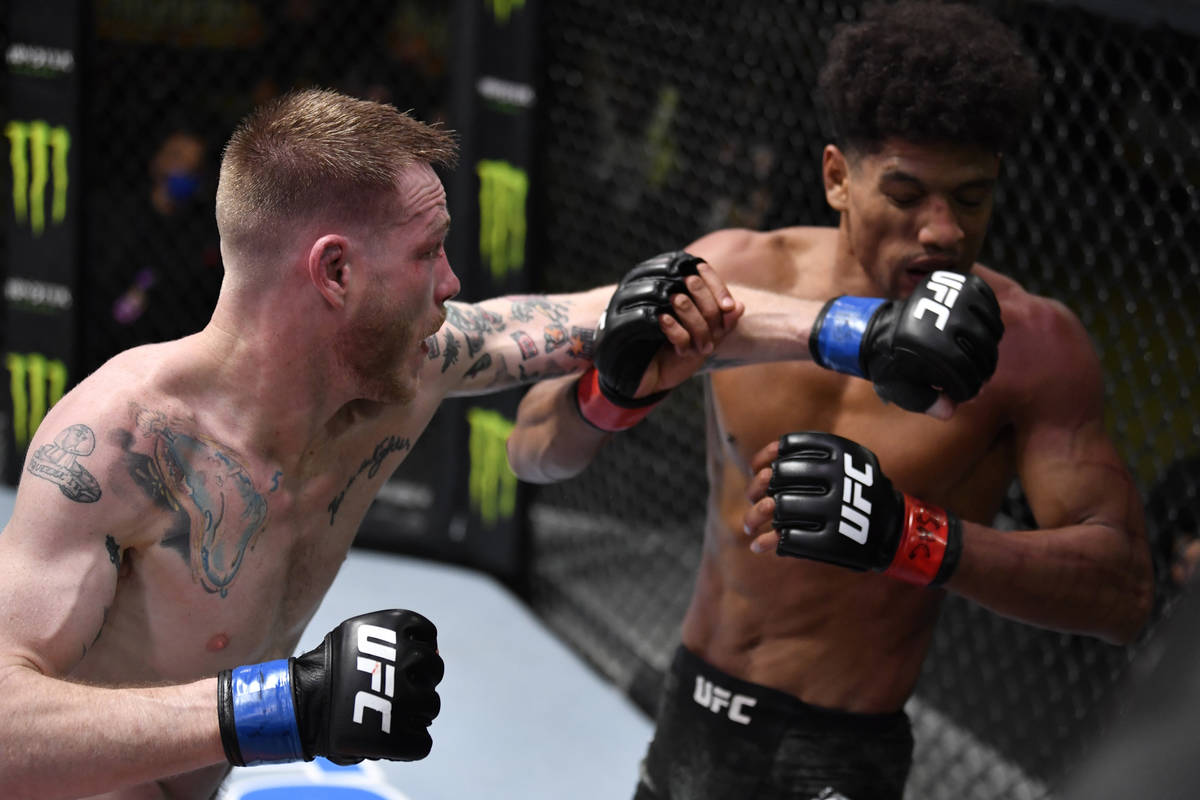 LAS VEGAS, NEVADA - FEBRUARY 27: (L-R) Kevin Croom punches Alex Caceres in a featherweight bout ...