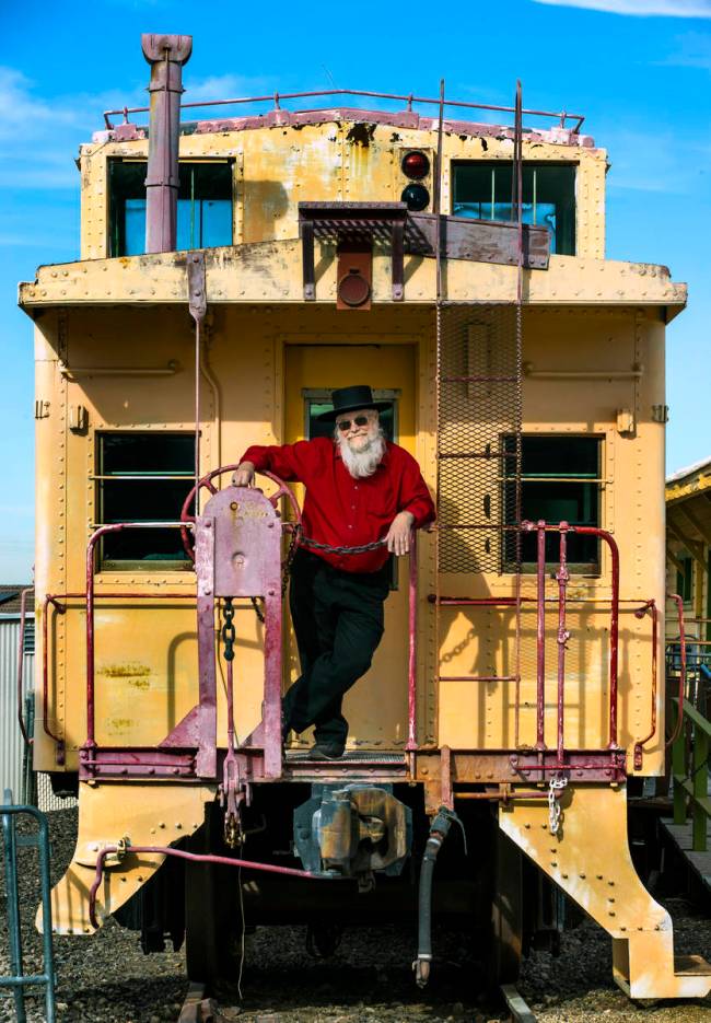 Mark Hall-Patton on the back of a caboose beside the former Boulder City Depot building at the ...