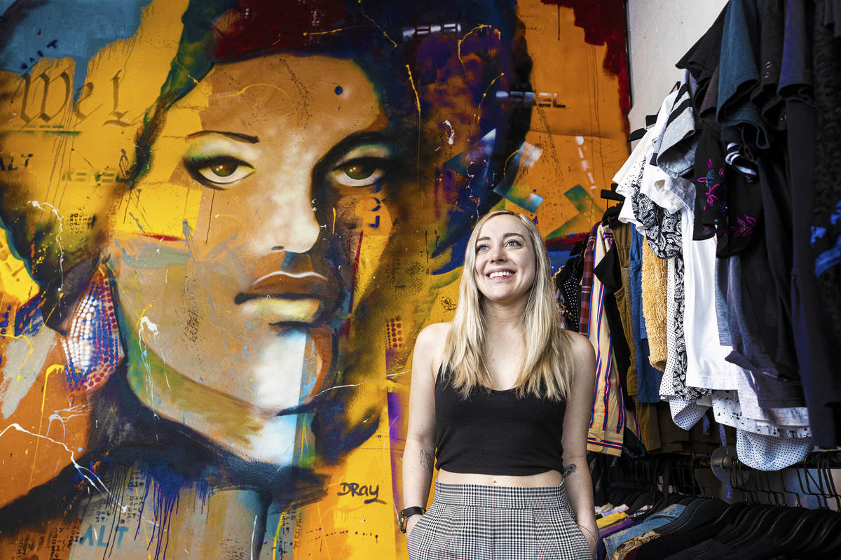 Alt Rebel vintage clothing store owner Taylor Rice poses with a mural of Black Panther organize ...