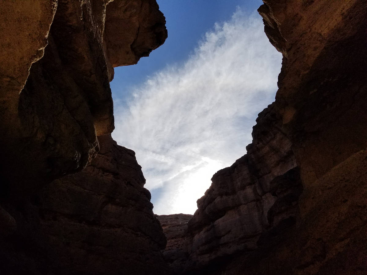 A large skylight of an opening between narrow rock walls inside the slot canyon. (Natalie Burt)