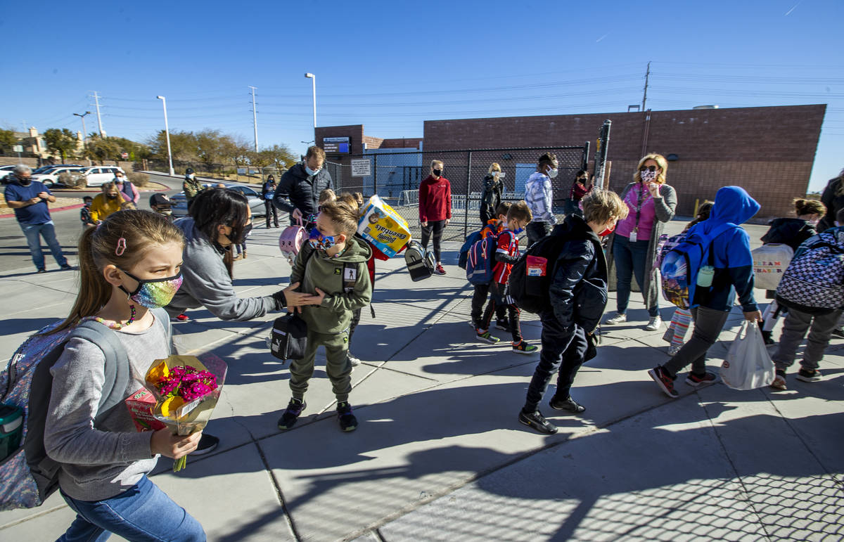 Students begin to enter a side gate at Goolsby Elementary School as they return to class on Mon ...