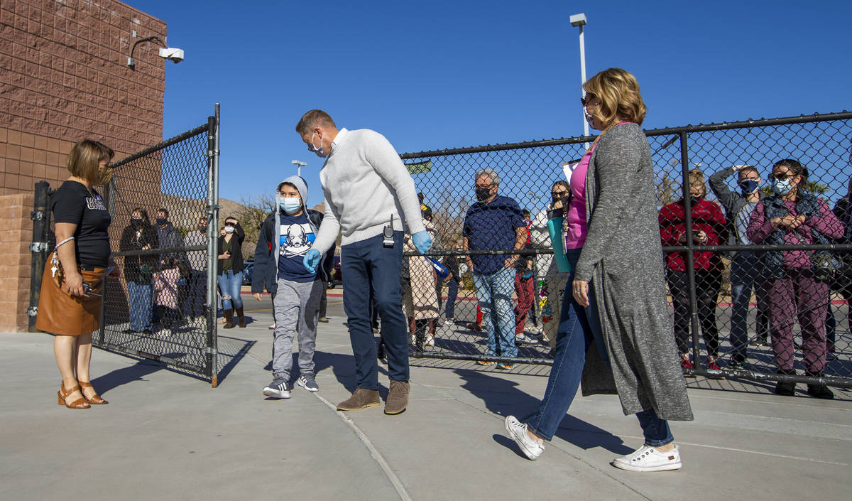 Vice principal Magdalena Casillas, from left, looks on as a student is welcomed in a side gate ...