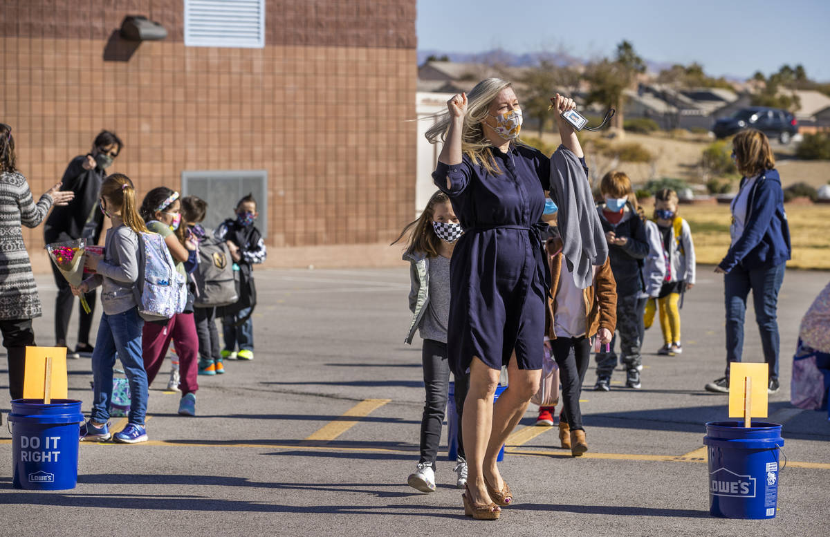 Teacher Alissa Miller is pumped up as she and other staff members lead students inside from the ...