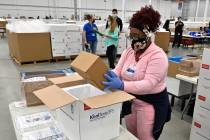 An employee with the McKesson Corporation packs a box of the Johnson and Johnson COVID-19 vacci ...