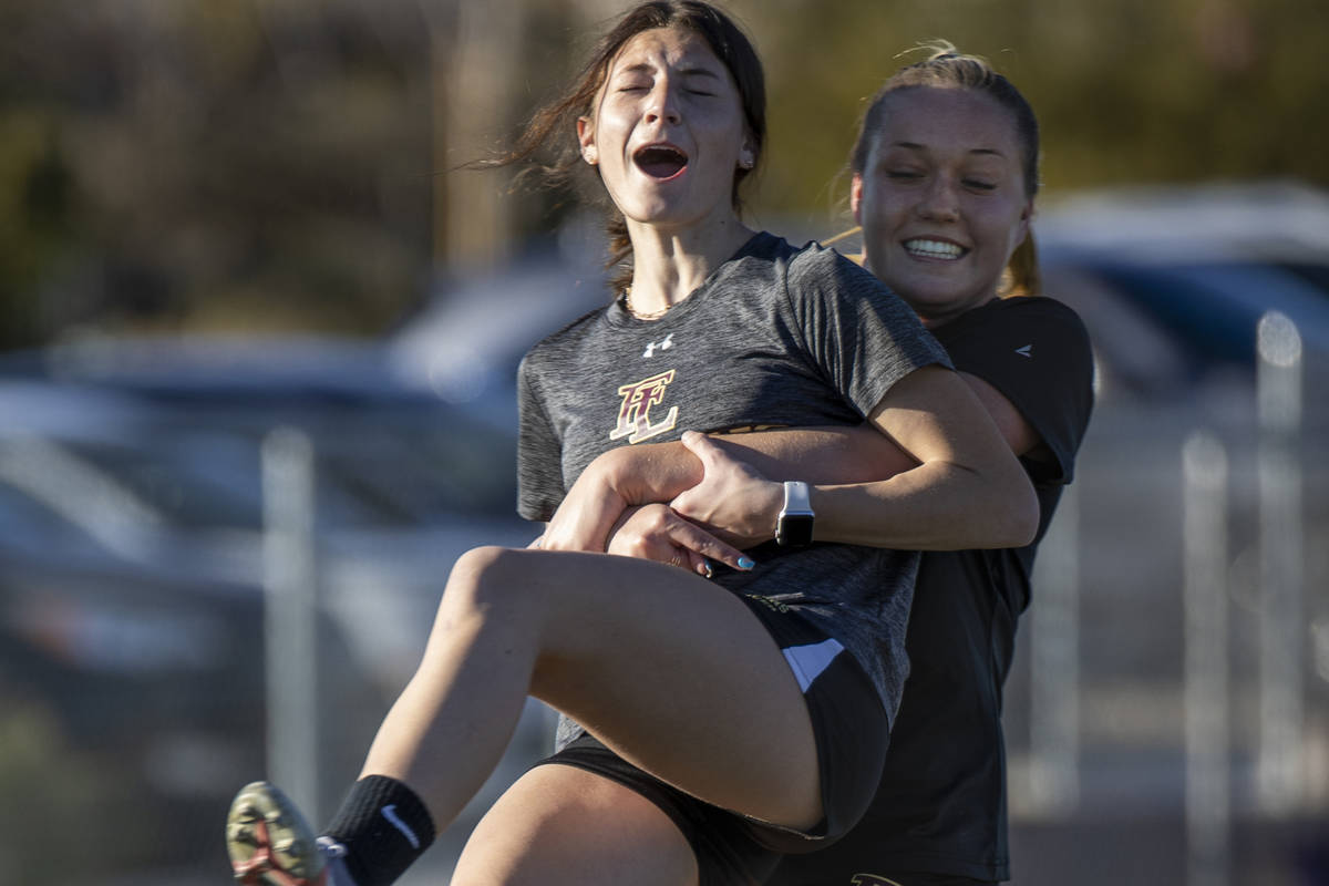 Player Camille Lomgabardi, left, is swung around by teammate Kennedy Lazeby kicks a ball up dur ...