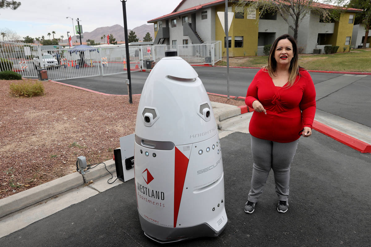 Regional Manager Carmen Batiz shows security robot "Westy" at Liberty Village Apartme ...