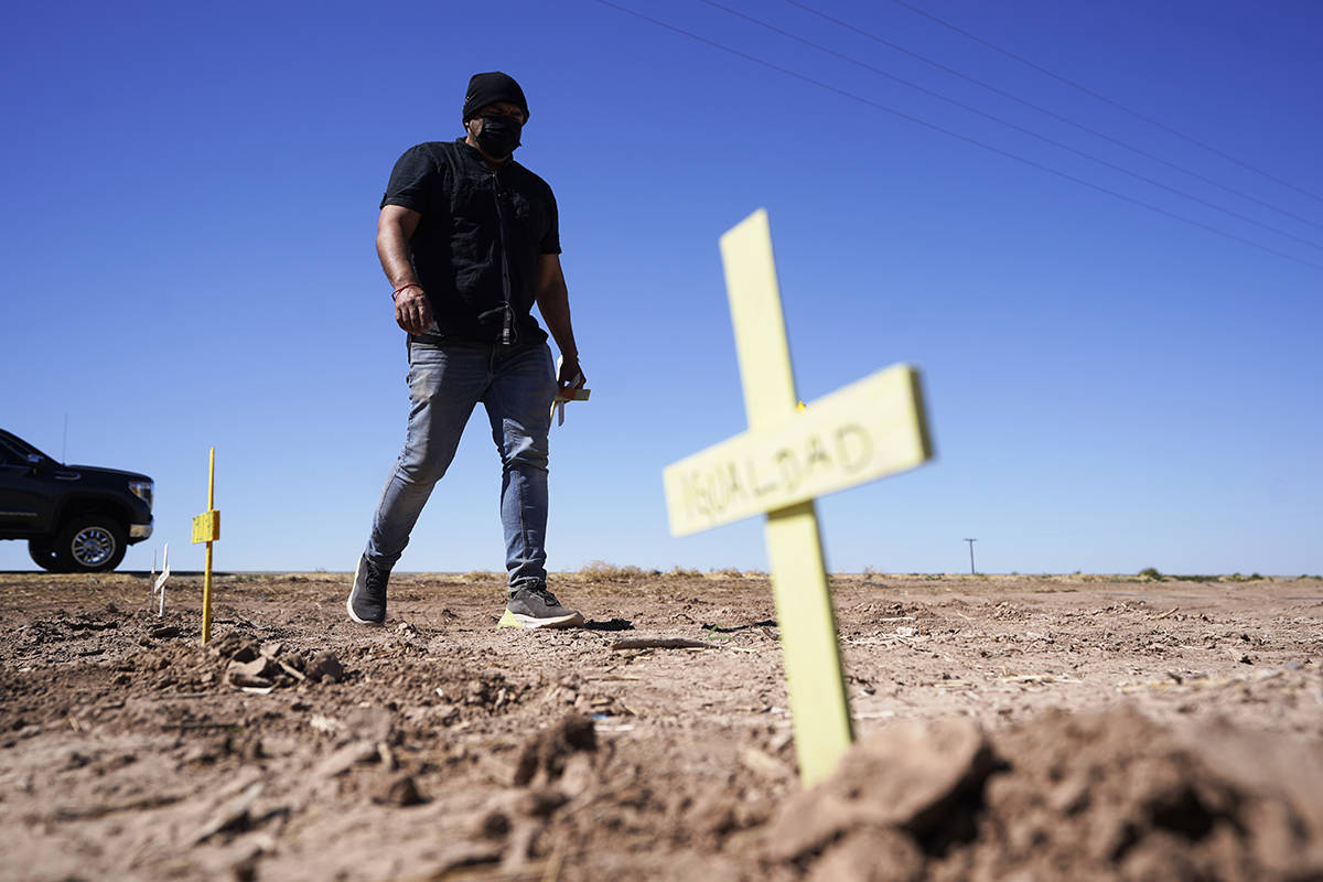 Hugo Castro leaves crosses at the scene of a deadly crash in Holtville, Calif., on Tuesday, Mar ...