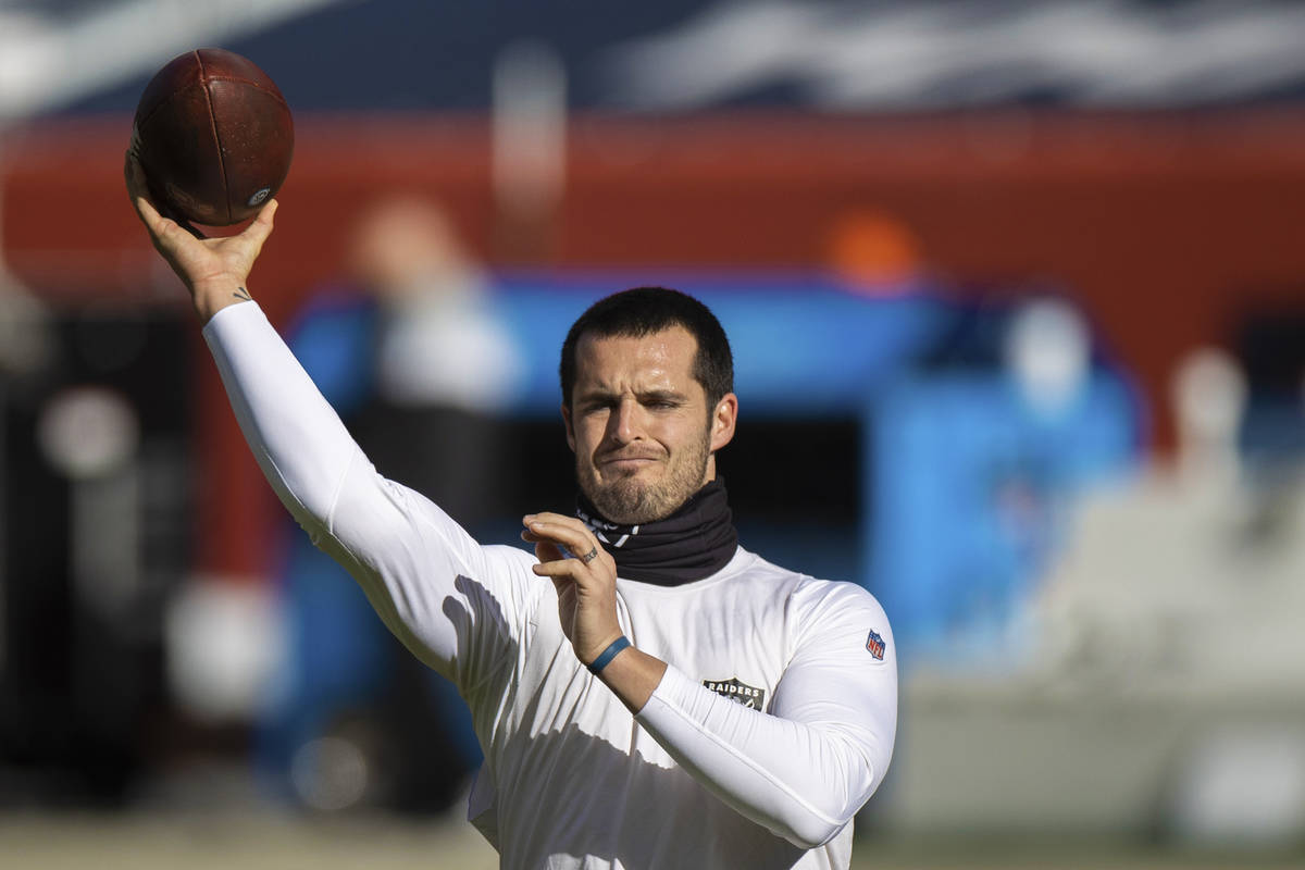 Raiders quarterback Derek Carr warms up before the start of an NFL football game against the De ...