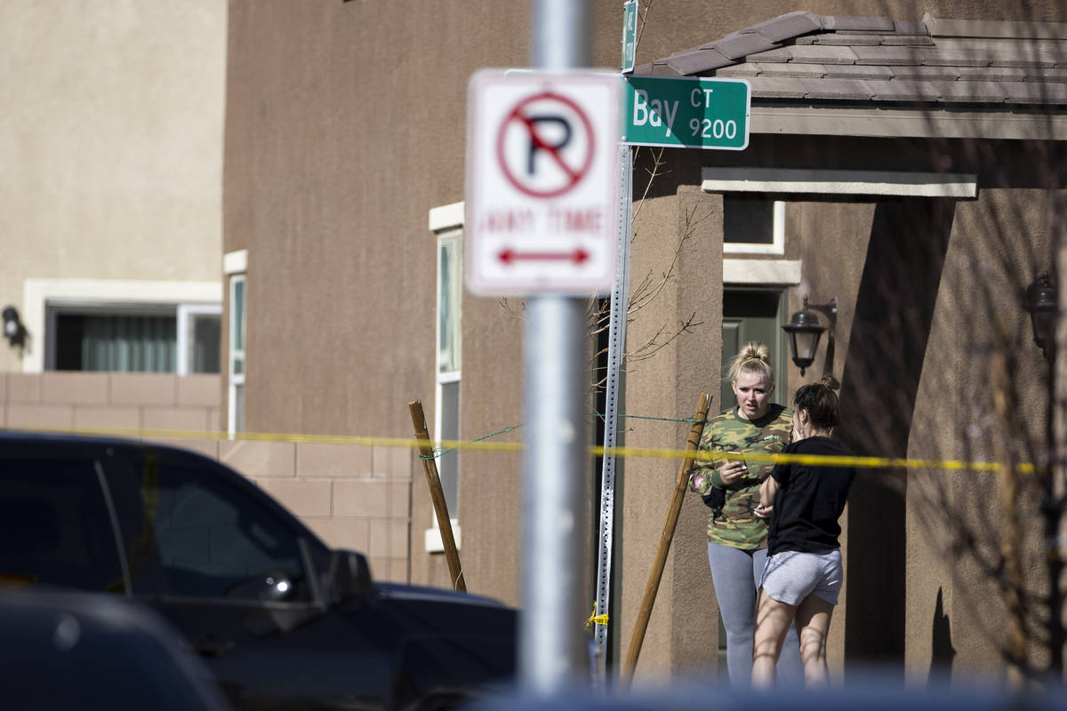 People watch outside of a home as Las Vegas police investigate an apparent murder-suicide insid ...