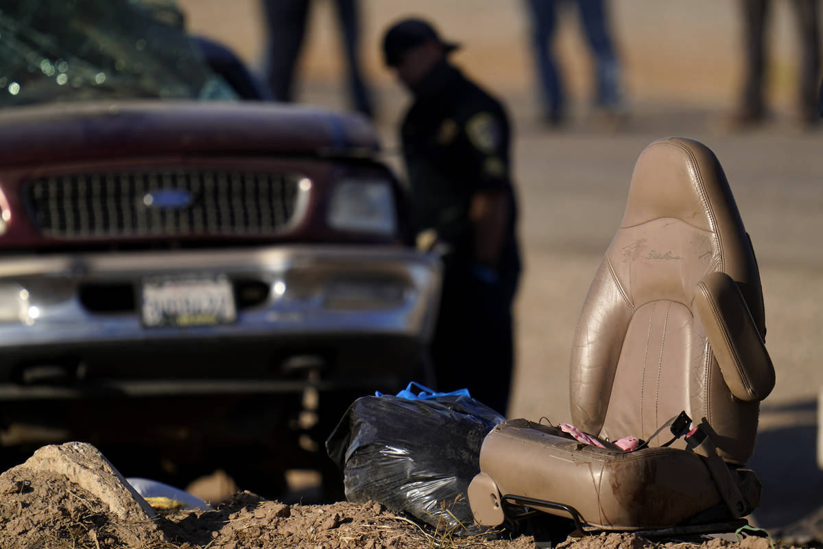A law enforcement officer examines the scene of a deadly crash in Holtville, Calif., Tuesday, M ...