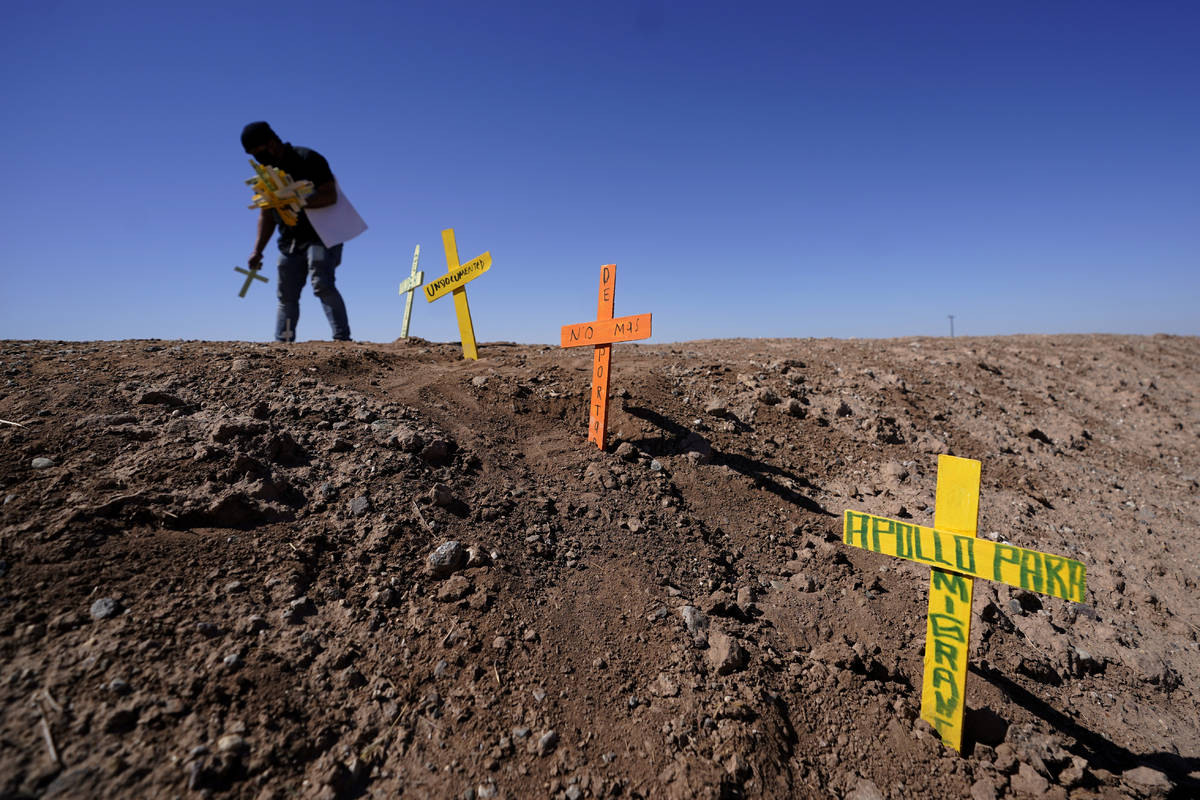 Hugo Castro leaves crosses at the scene of a deadly crash in Holtville, Calif., Tuesday, March ...