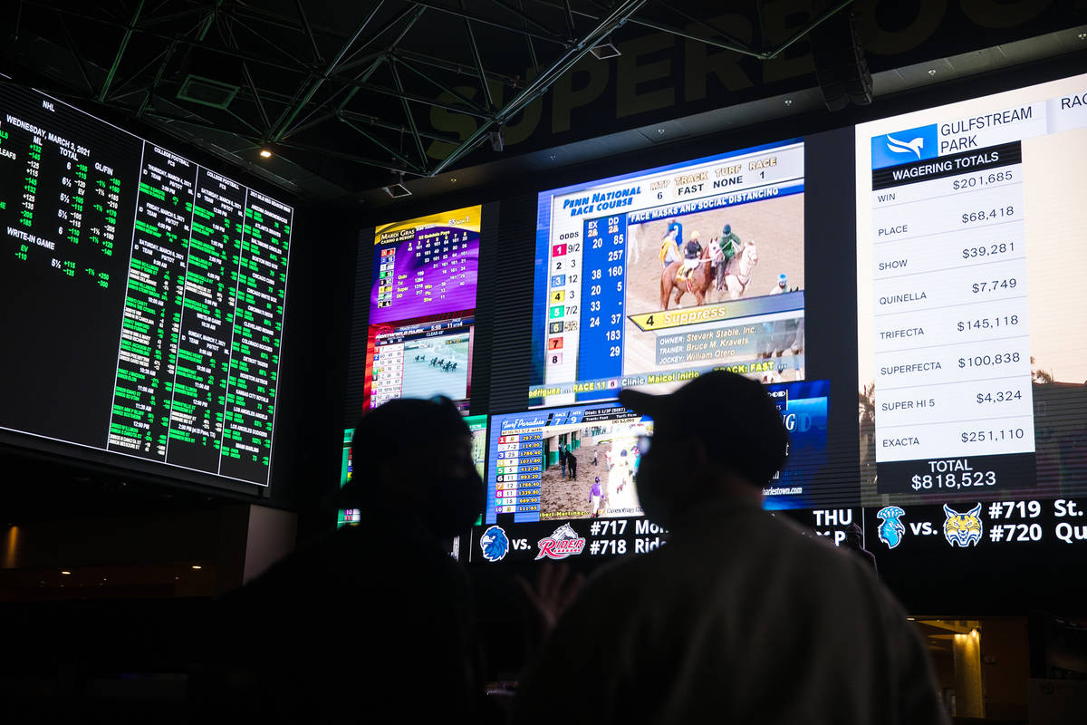 Bob Butler, left, and Richard Hoffman, right, watch the betting screens at the Westgate sportsb ...