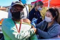 Debbie Min, a physician assistant student from Touro University, administers a COVID-19 vaccine ...