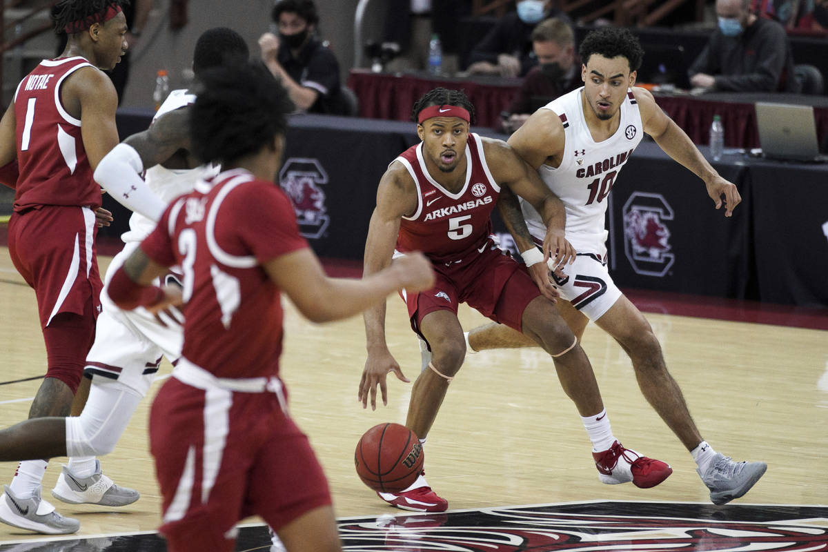 Arkansas guard Moses Moody (5) dribbles next to South Carolina forward Justin Minaya (10) durin ...