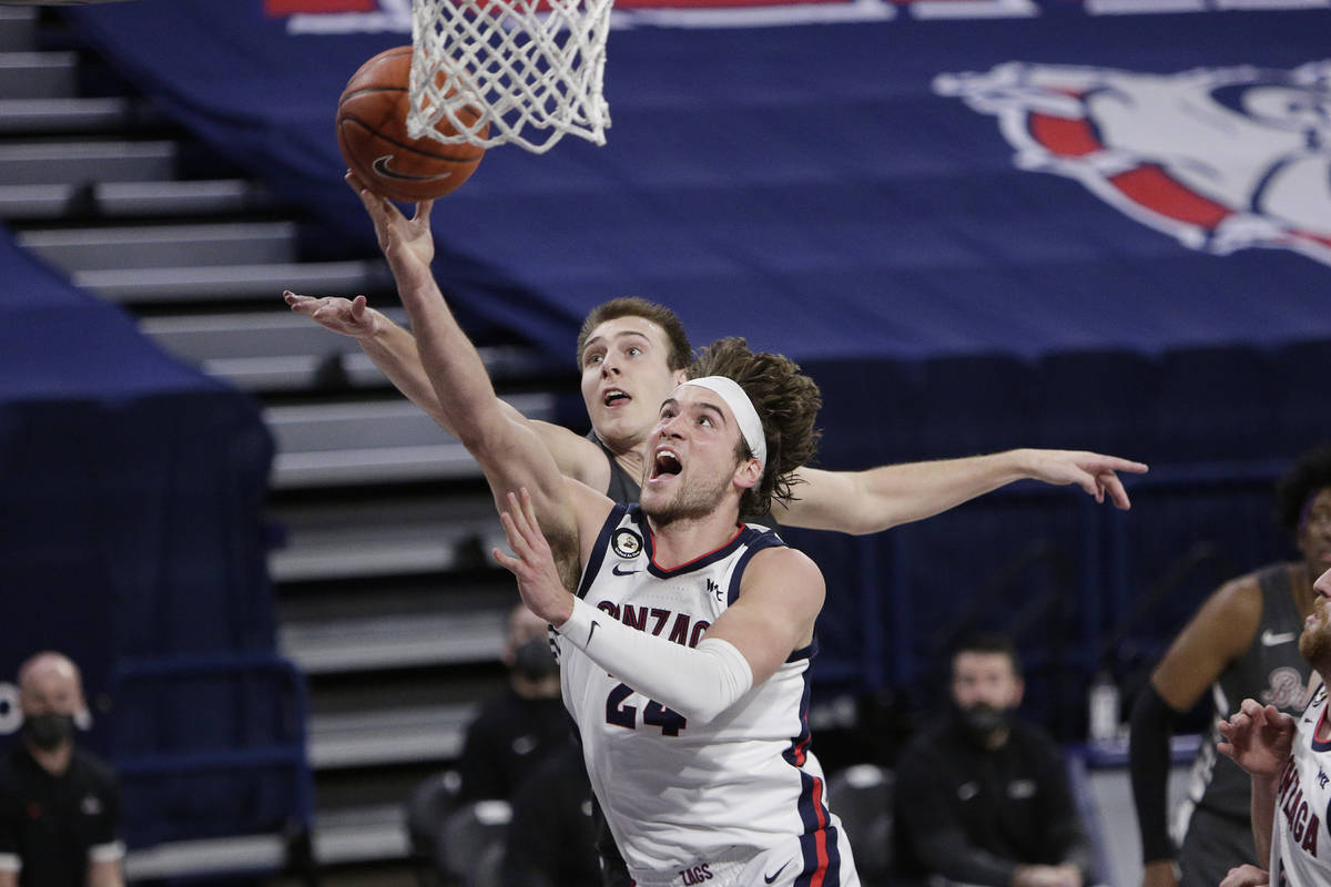 Gonzaga forward Corey Kispert, front, shoots in front of Santa Clara forward Josip Vrankic duri ...