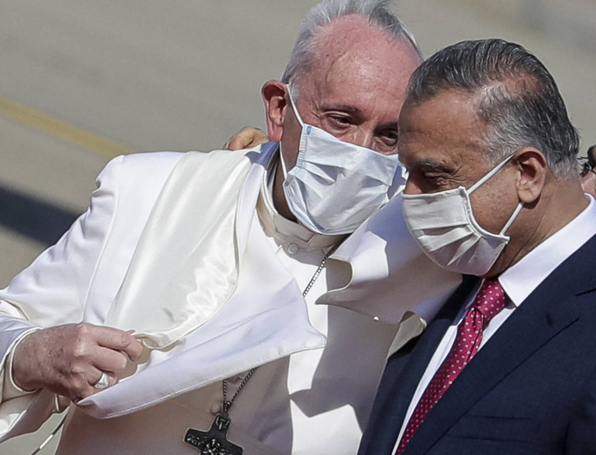 Pope Francis is greeted by Iraqi Prime Minister Mustafa al-Kadhimi as he arrives at Baghdad's i ...