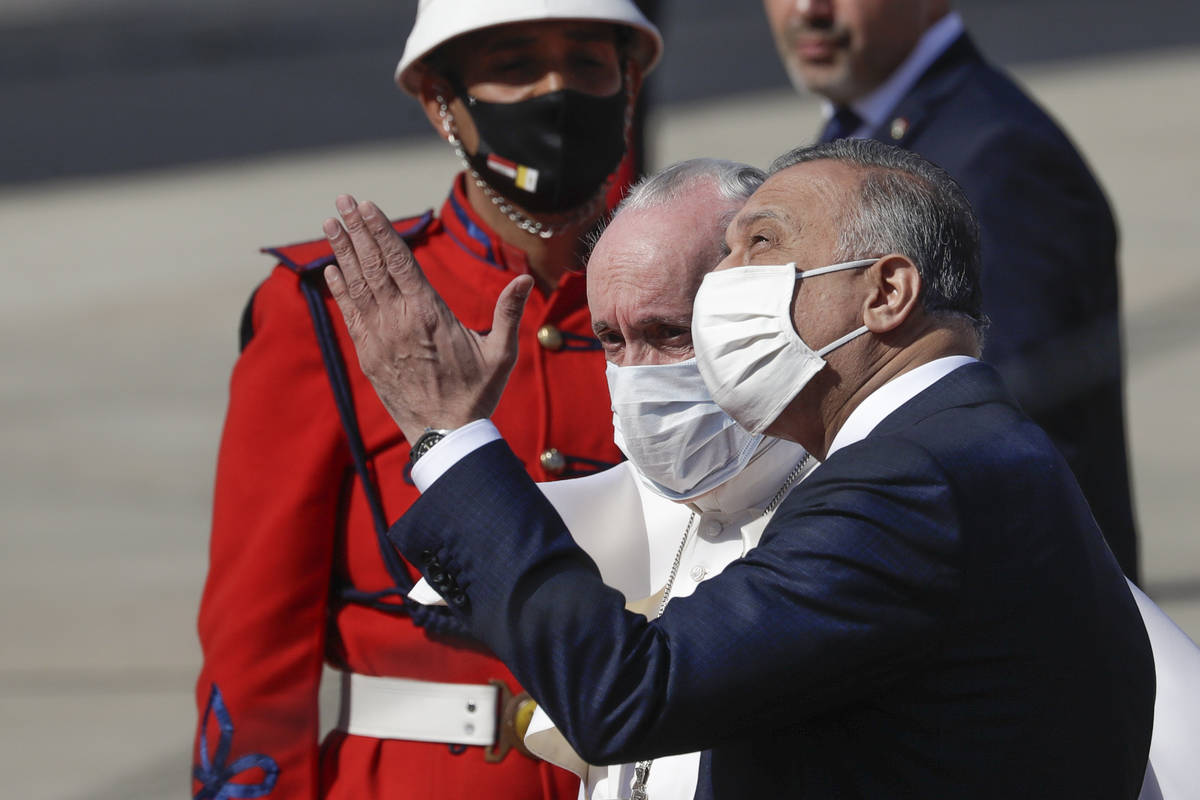 Pope Francis is greeted by Iraqi Prime Minister Mustafa al-Kadhimi as he arrives at Baghdad's i ...