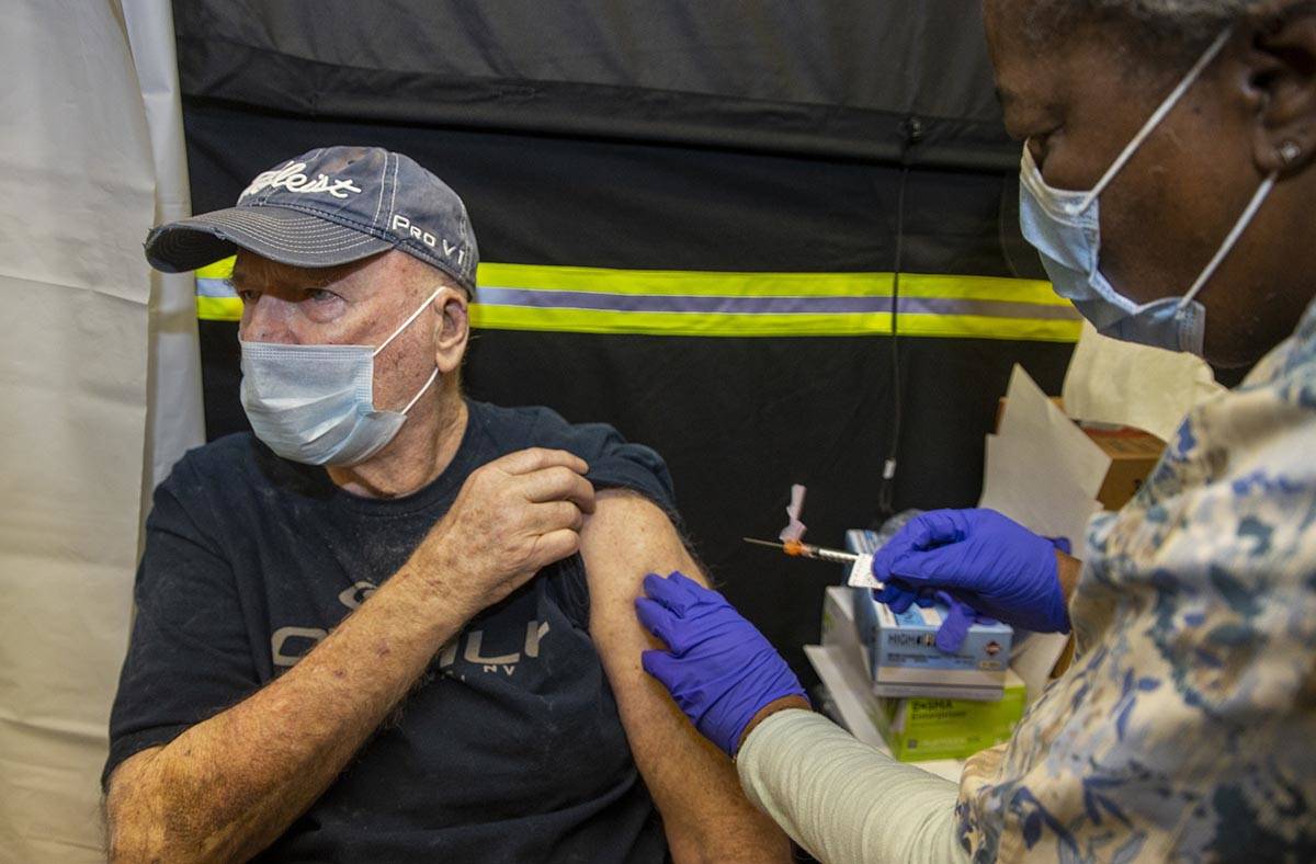 Veteran Jack Daughtrey, left, receives a shot from RN Francine Jones-Toliver as some of the fir ...