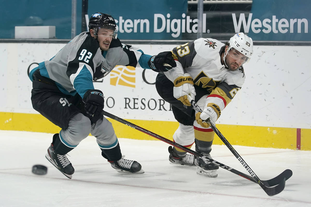 Vegas Golden Knights defenseman Alec Martinez, right, passes the puck in front of San Jose Shar ...