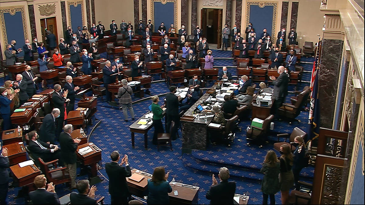 In this image from video, senators stand and applaud support staff, before the final vote on th ...